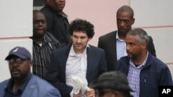 FTX 创始人山姆·班克曼-弗里德(中)在同意被引渡到美国后,于2022年12月21日从巴哈马拿骚地方法院护送出来。(美联社照片)