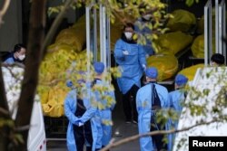 上海一家火葬场的工作人员走过数个逝者的尸袋。(2023年1月4日)