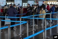 北京国际机场一个国际航班柜台的旅客等候托运行李。(2022年12月29日)