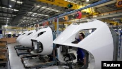 资料照:上海一家工厂的工人在高铁火车配件生产线上。(2022年7月21日)