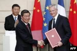 资料照:中国发改委主任何立峰与法国经济与财政部长布鲁诺·勒梅尔(右)在法国爱丽舍宫签署协议后,中国领导人习近平为其鼓掌。(2019年3月25日)