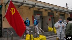 2022年3月17日北京一个封闭社区外,工作人员在聊天。