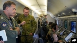 印太美军司令约翰∙阿奎利诺(左)海军上将在美国海军一架飞临南沙群岛上空的P-8A“波塞冬”侦察机上观看中国在人工岛上建造的建筑物的视频。 (2022年3月20日)