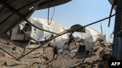 一名男子在加沙地带汗尤尼斯一处一天前被以色列空袭的地点查看现场。(2018年5月30日)