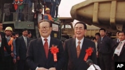 1997年11月8日,三峡工程大江截流成功,中国主席江泽民和总理李鹏(右)在三峡工程工地祝贺职工们。