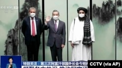 中国央视播放时任中国外长王毅在安徽屯溪会晤到访的巴基斯坦外长沙阿·马哈茂德·库雷希(左)和塔利班任命的阿富汗外长阿米尔·汗·穆塔基(右)的影像。(2022年3月30日)