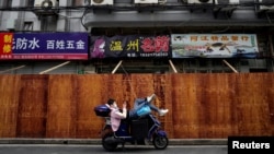 3月30日,上海一封闭小区外面一位躺在电动车上的男子正看着自己的手机。由于新冠病毒感染者持续飙升,上海政府决定实行“分区封控”措施。