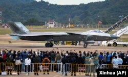 在第14届珠海航空航天展览会上,中国制造的歼-20重型隐身战斗机停在跑道上供参观者拍照。(2022年11月8日)