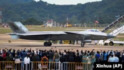 在第14届珠海航空航天展览会上,中国制造的歼-20重型隐身战斗机停在跑道上供参观者拍照。(2022年11月8日)