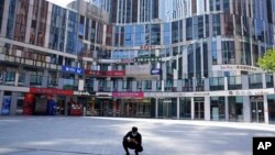 一名男子蹲在北京一处被关闭了的商场前。( 2022年5月2日