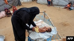 一名也门妈妈在照顾她的因营养不良而骨瘦如柴的4岁幼儿。(2021年3月2日)