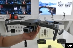 资料照:中国大疆一名雇员在上海展示新型无人机。(2019年5月22日)