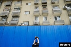 工人在北京市一个居民小区楼外竖起屏障进行封闭。(2022年4月29日)