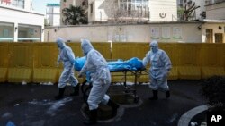 武汉一所医院的医护人员正在转移新冠病毒死亡病人。(2020年2月16日)