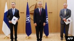 北约秘书长斯托尔滕贝格(中)与芬兰驻北约大使科尔霍宁(左)和瑞典驻北约大使韦恩霍夫(右)在布鲁塞尔出席两国加入北约的申请仪式。(2022年5月18日)