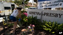 美国南加州基督长老会教堂前,一名女子在给5月15日枪击案的死难者献花。(2022年5月16日)
