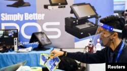 台湾一名戴着口罩和面罩的工作人员在为台北国际电脑展览会开幕做准备。(2022年5月24日)