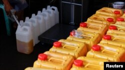 အင်ဒိုနီးရှားနိုင်ငံ၊ ဂျကာတာမြို့ စားအုံးဆီအရောင်းဆိုင်မှာ အလုပ်သမားတဦး ဆီဖြည့်နေစဉ်။