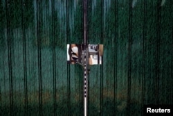 一名女子从因防疫被锁住的住宅小区门里向外张望。(2022年5月24日)