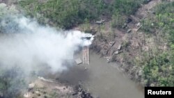 Khói bốc lên từ cây cầu có vẻ như bị đánh sập bắc qua sông Siverskyi Donets trong bức ảnh được công bố vào ngày 12/5/2022.