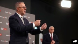澳大利亚工党领袖安东尼∙阿尔巴尼斯(Antony Albanese)(左前)在大选中战胜现任总理斯考特∙莫里森(Scott Morrison)为首的执政的保守派联盟。图为阿尔巴尼斯和莫里森2022年4月20日选前辩论。-美联社照