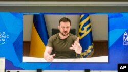 Ukrainian President Volodymyr Zelenskyy is seen on a screen as he addresses the audience from Kyiv during the World Economic Forum in Davos, Switzerland, May 23, 2022.