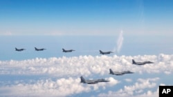 资料照片:2022年5月25日,日本和美国战斗机在日本海上空联合巡航。(美联社照片)