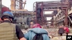 FILE - This frame taken from an undated video provided Sunday, May 1, 2022 by the Azov Special Forces Regiment of the Ukrainian National Guard shows people walking over debris at the Azovstal steel plant, in Mariupol, eastern Ukraine.