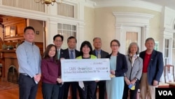 台美人社团代表2022年5月23日在华盛顿双橡园的仪式中将捐款支票交给非盈利组织“关怀国际”首席营运官格洛丽雅·斯蒂尔(左二)(美国之音锺辰芳拍摄)