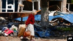 Мешканка на зруйнованій вулиці Маріуполя 27 травня 2022 року. АР/ Олексій Олекандров.