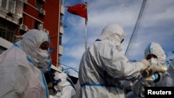 身穿防护服的人员准备进入北京一个被封控的居民小区。(2022年11月12日)