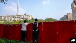 中国广东广州被封的海珠区居民从围栏里向往张望。(2022年11月11日)