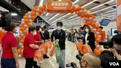 受疫情影響停駛接近3年的廣深港高鐵香港段1月15日復運,入境大堂有歡迎旅客抵達香港的佈置,有港鐵職員手持紀念品列隊迎接旅客 (美國之音/湯惠芸)