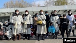 资料照:上海一家火葬场外身穿孝服的亲属为离世的亲人送行。(2023年1月4日)