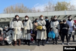 上海一家火葬场外身穿孝服的亲属为离世的亲人送行。(2023年1月4日)