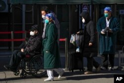 北京一家医院外一位坐轮椅排队离开发热门诊的老年病患。（2022年12月19日）