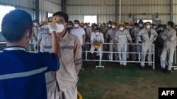 2020年1月30日位于印尼苏拉威西岛莫罗瓦利县中国拥有的镍工业冶炼厂工人接受新冠体温检查