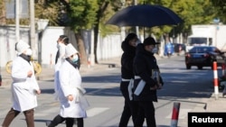 上海一家火葬场外身穿孝服的亲属手捧逝去亲人的遗像。(2022年12月23日)