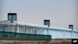 资料照片:2021年4月23日,一个警卫站在中国西部新疆维吾尔自治区达坂城第三看守所周边的一座塔楼里。