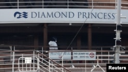 停泊在日本横滨港的“钻石公主号”游轮上一名身穿防护服的工作人员(2020年2月20日)