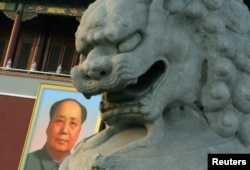 资料照:北京天安门城楼悬挂的毛泽东画像与城楼前的石狮。
