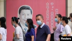 上海民众走过街头树立的一面中国领导人习近平的宣传画。(2022年8月31日)