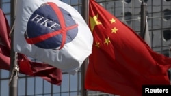 资料照:中国国旗在香港交易所的旗帜旁飘扬。