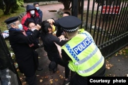 一名示威者被人拉入中国领事馆范围内,并遭多人围殴脚踢。英国警察见状立刻冲入领事馆范围内,将被围殴的人救出。 (照片来源:Matthew Leung/追新闻提供)