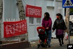 北京居民走过一个新冠病毒疫苗流动接种点。(2022年10月26日)