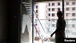 资料照:中国广西桂林的徐女士住进了三年前她从房地产公司佳登宝购买的未通水电的烂尾公寓。(2022年9月17日)