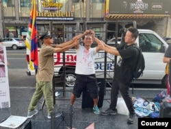 前中国“精神病监狱”受害者界立建和一群海外维权人士10月10日于美国洛杉矶好莱坞星光大道的中国剧院旁透过演示,还原中共利用名为“安康”的精神病监狱制度迫害异议人士的暴行(照片提供:界立建)。