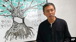 资料照:2021年1月14日,曾在多家香港媒体机构工作的资深记者和教学顾问区家麟在香港的一个电视节目中发表讲话。(美联社)