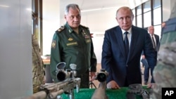 俄罗斯总统弗拉基米尔·普京和俄罗斯国防部长谢尔盖·绍伊古在莫斯科郊外的军事展览中心观看狙击步枪。(2018年9月19日)