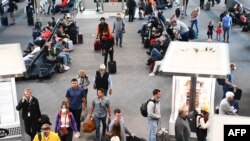 2022年4月19日,在联邦法官宣布对公共交通系统的口罩要求不再有效的一天后,美国科罗拉多州丹佛机场航站楼内一些准备搭机的乘客,已经不再佩戴口罩。